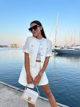 a lady wears a white blazer and matching shorts
